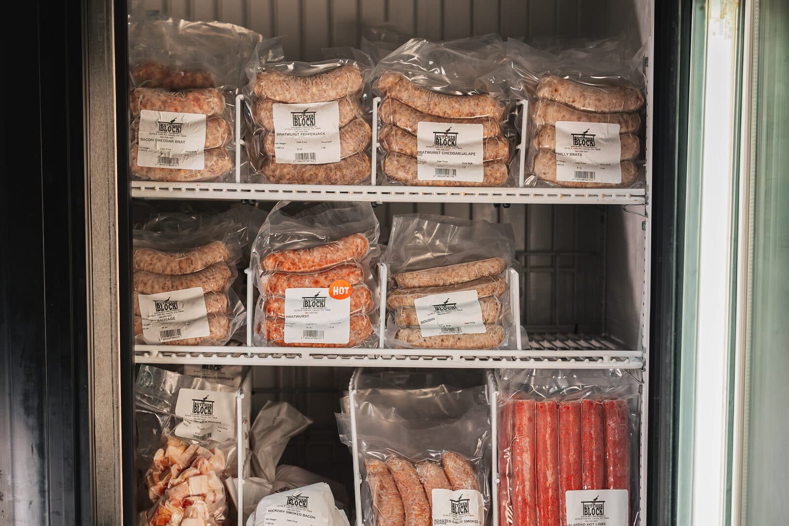 Packages of bratwurst and hickory smoked bacon in the freezer